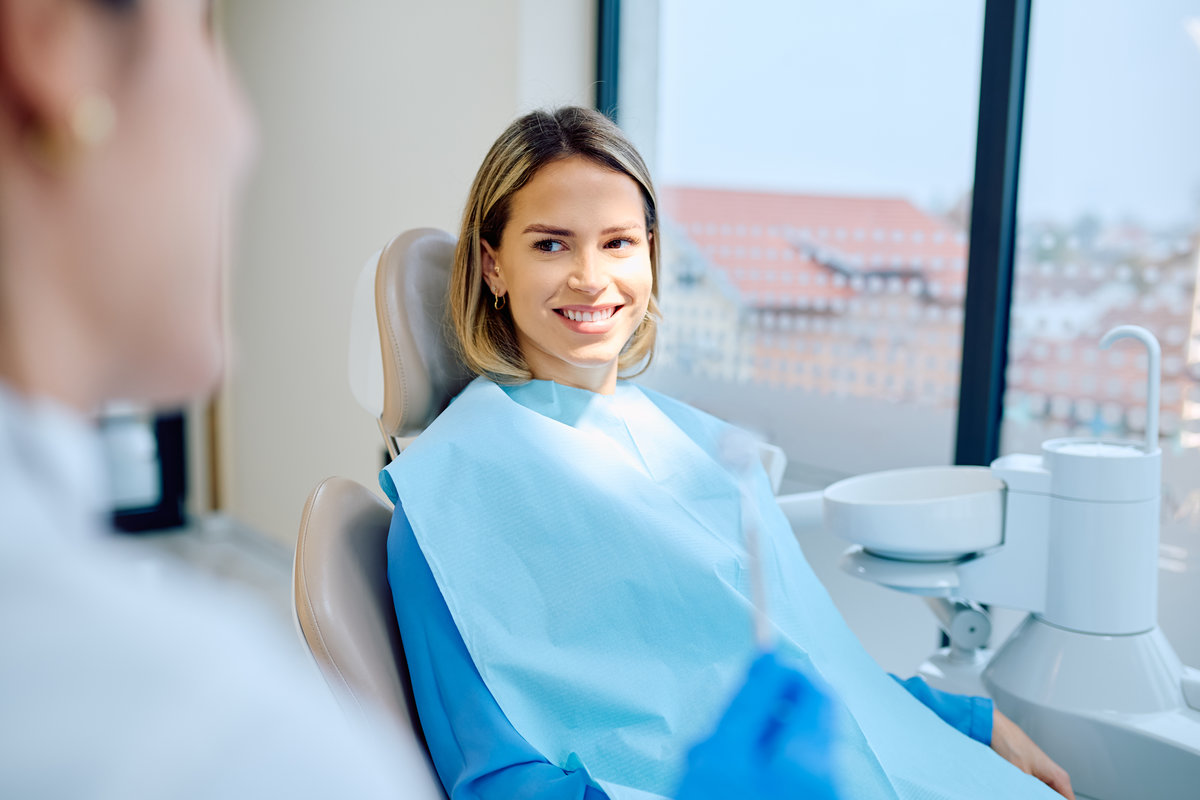 Happy woman patient smiling in dental office chair