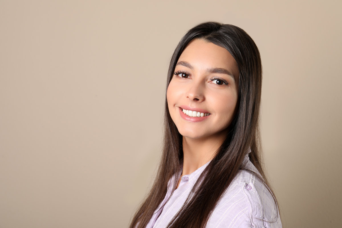 Young woman with healthy teeth on color background. Space for text